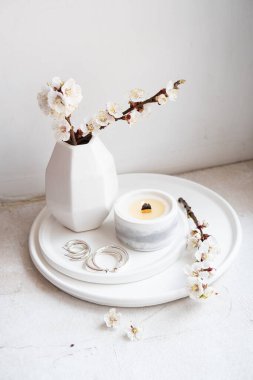 Çiçek açan kayısı dalları vazoda ve yanan mumlar ev içinde yuvarlak tepside