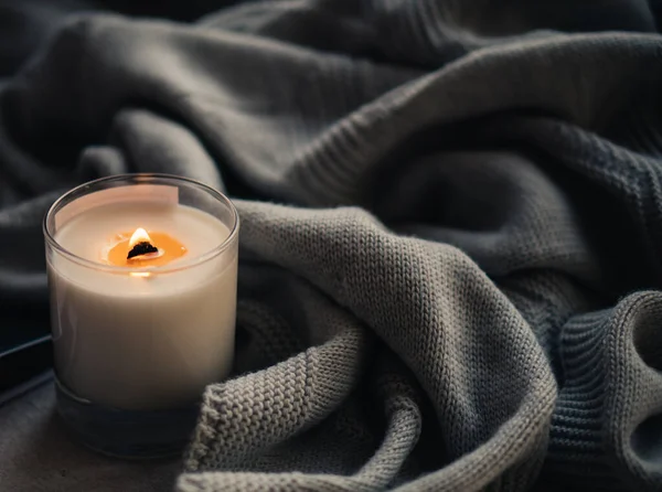 Brandende kaars in glas met houten lont, handgemaakte natuurlijke waskaars met gebreide deken — Stockfoto