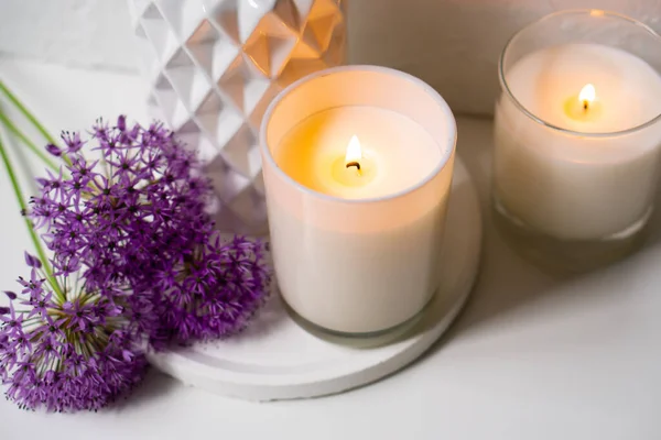 Candela ardente e fiori di allium viola su vassoio bianco — Foto Stock