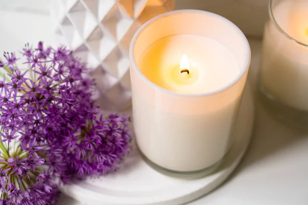 Burning candle and violet allium flowers on white tray — Stock Photo, Image