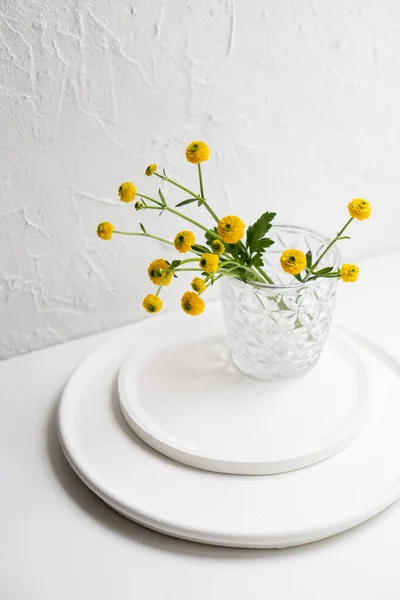 White home decoration with yellow flowers, ceramic vase and glass on tray — Stock Photo, Image