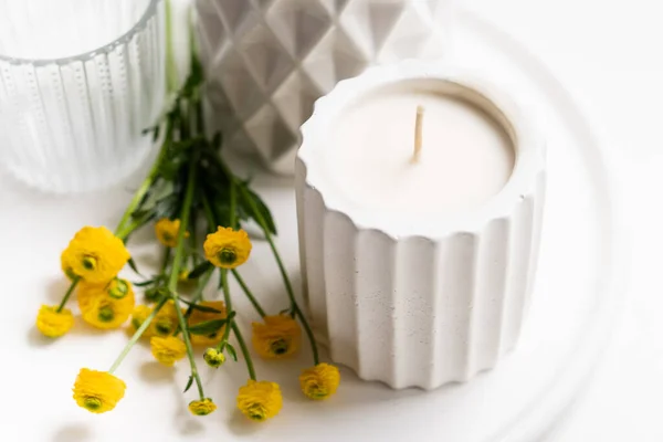 白色家居装饰，黄色花朵，陶瓷花瓶，蜡烛和杯子放在盘子里 — 图库照片