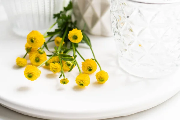 Decoración blanca para el hogar con flores amarillas, jarrón de cerámica y vidrio en bandeja —  Fotos de Stock