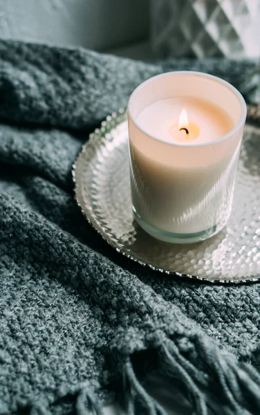 Белая горящая свеча в стеклянном подсвечнике на винтажном металлическом подносе, теплый уютный дом — стоковое фото