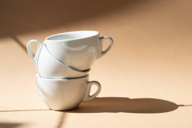 Bej renkli stüdyo arka planında üç seramik bardak.