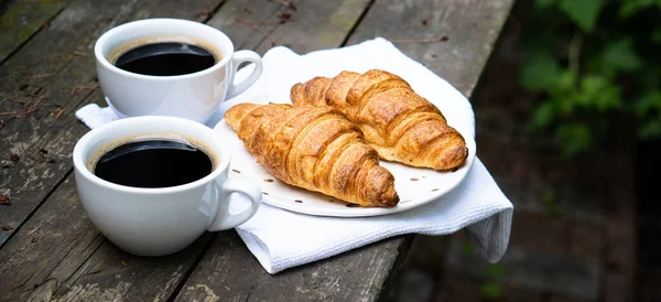Café e croissants na velha mesa de madeira rústica — Fotografia de Stock