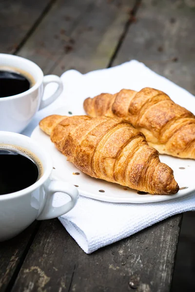 Coffee and croissants on old rustic wooden table — Stock Photo, Image