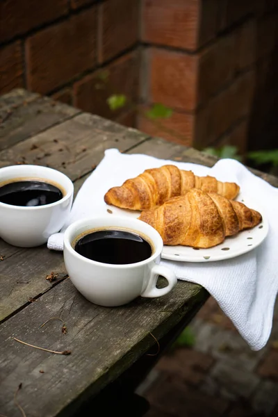 Kávé és croissant a régi rusztikus fa asztalon — Stock Fotó
