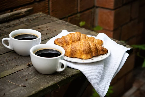 Coffee and croissants on old rustic wooden table — Stock Photo, Image