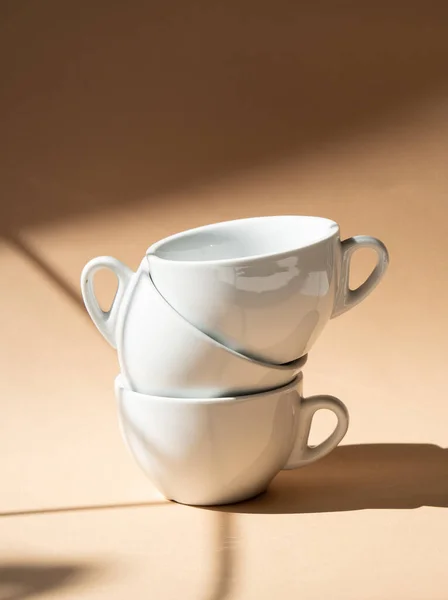 Three ceramic cups on beige studio background — Stock Photo, Image