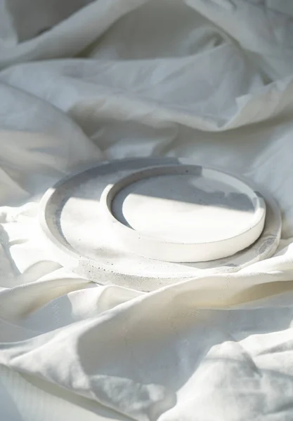 Leeres rundes Tablett auf weißem, strukturiertem Leinenhintergrund, Designer-Schmuckteller — Stockfoto