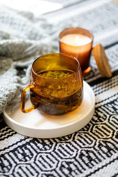 Cup of tea and cozy burning candle on white tray — Stock Photo, Image