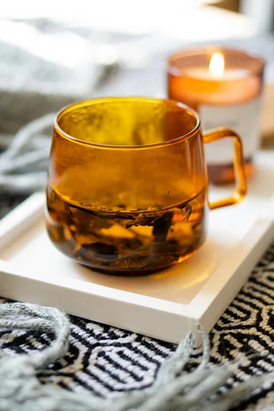 Xícara de chá e vela ardente acolhedora na bandeja branca — Fotografia de Stock