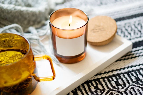 Gelbe transparente Tasse Kräutertee und gemütliche brennende Kerze mit Aufkleber-Attrappe — Stockfoto