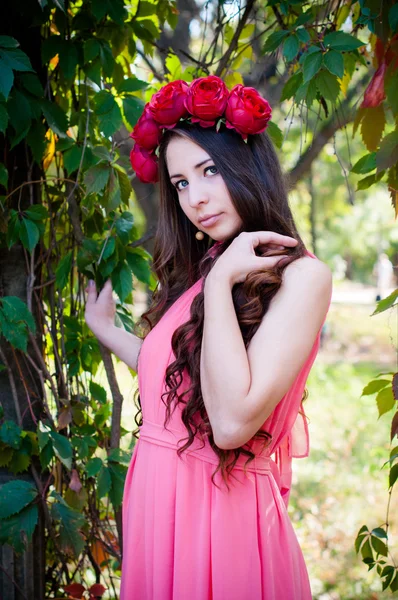 Mädchen mit einer Krone aus Rosen — Stockfoto