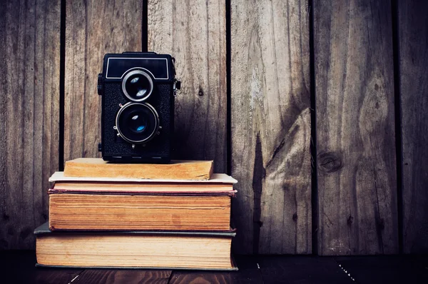 Kamera och en trave böcker — Stockfoto