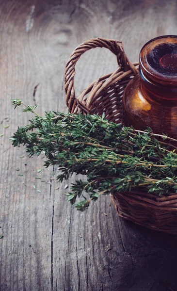 Apothekenflasche und Thymian im Korb — Stockfoto