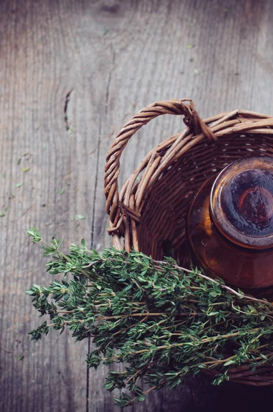 Apotheek fles en tijm in een mand — Stockfoto