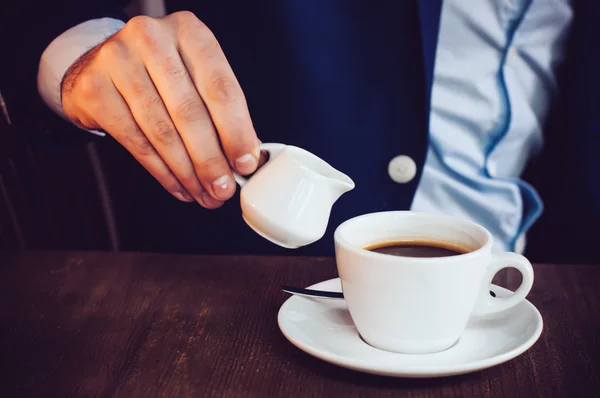 Cream into coffee — Stock Photo, Image