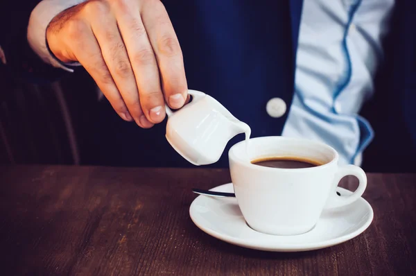 Cream into coffee — Stock Photo, Image