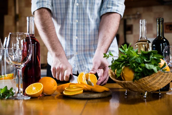 Man cuts oranges — Stock Photo, Image