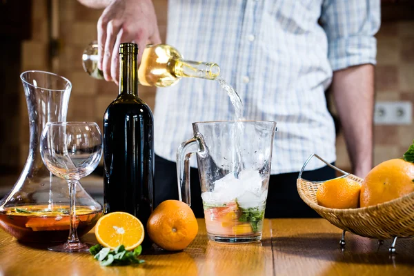 Man pouring white wine into a jar