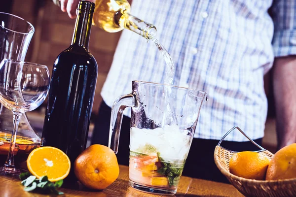 Man pouring white wine into a jar — Stock Photo, Image