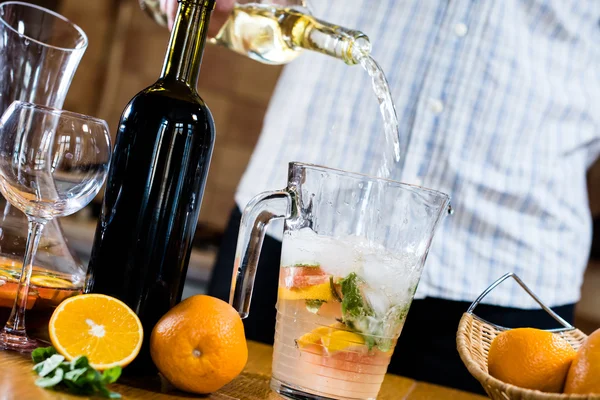 Man pouring white wine into a jar — Stock Photo, Image