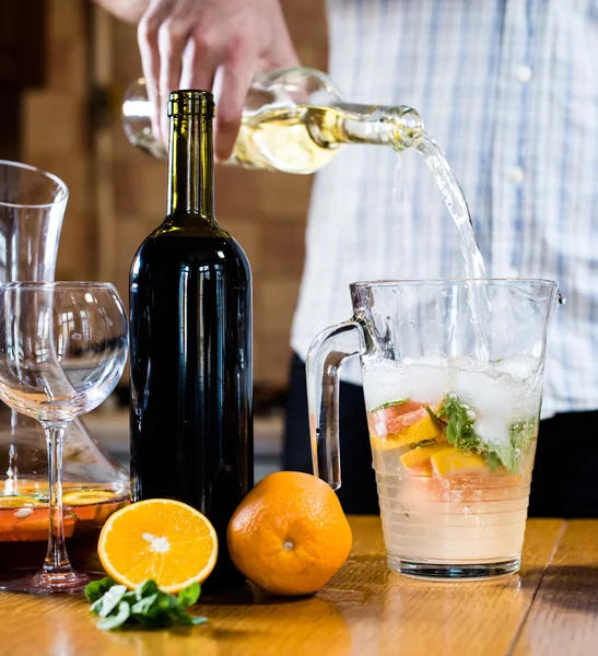 Man pouring white wine into a jar — Stock Photo, Image