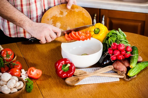 Man snijdt lente verse groenten — Stockfoto