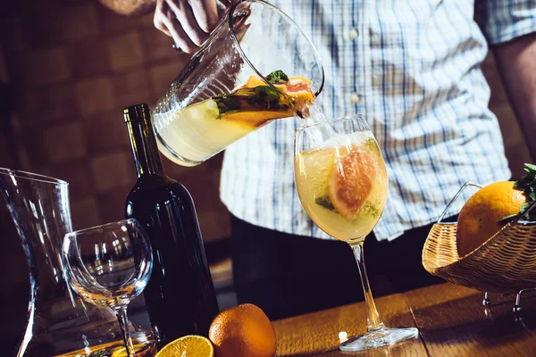 Man pours white homemade sangria — Stock Photo, Image