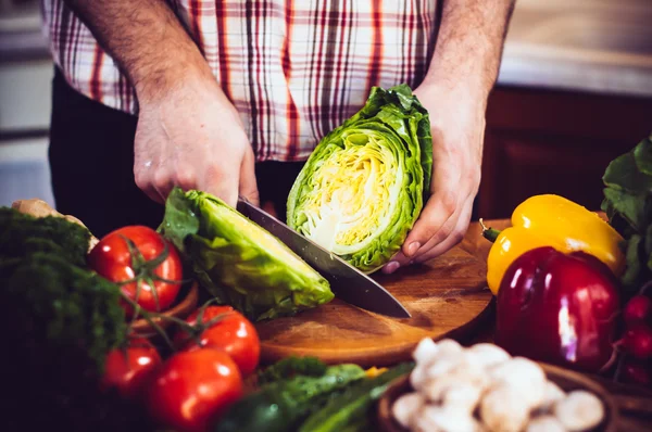 Man cuts fresh spring vegetables — Stock Photo, Image