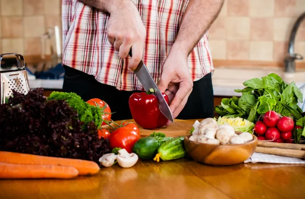 Man cuts fresh spring vegetables — Stock Photo, Image