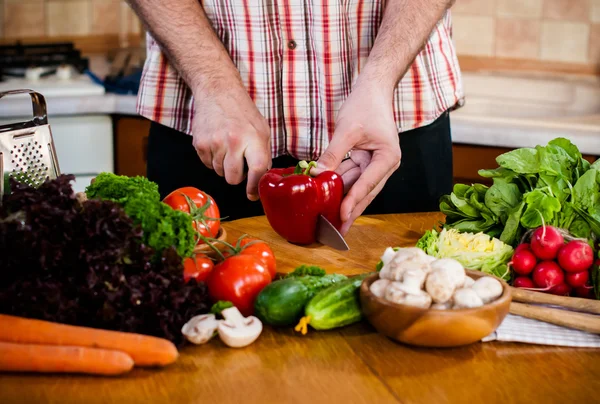 Man cuts fresh spring vegetables — Stock Photo, Image