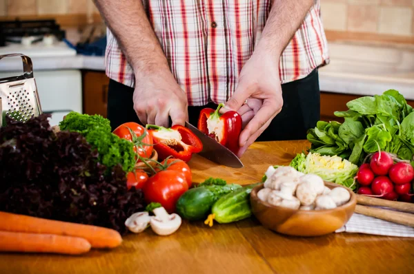 Man cuts fresh spring vegetables — Stock Photo, Image