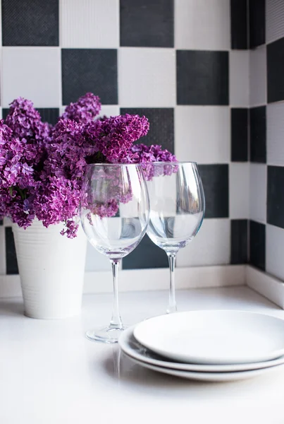 Lilacs in a vase and glasses — Stock Photo, Image