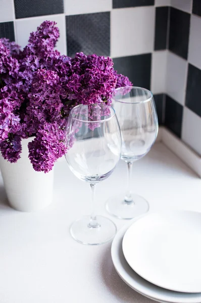 Lilacs in a vase and glasses — Stock Photo, Image