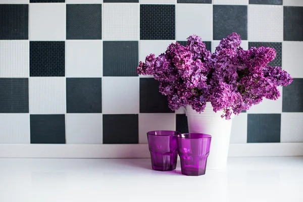 Lilas en un jarrón y vasos — Foto de Stock