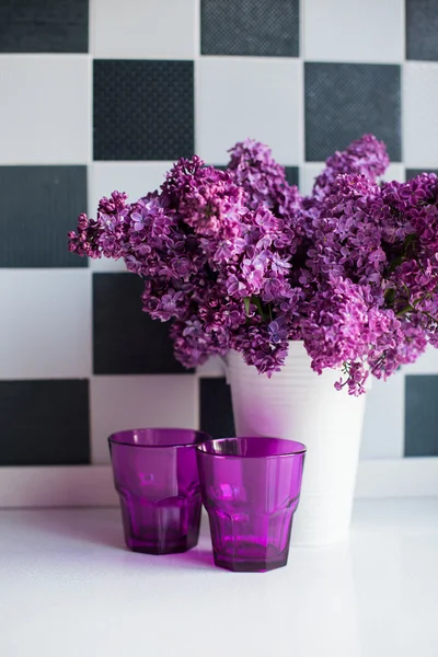 Lilas en un jarrón y vasos — Foto de Stock