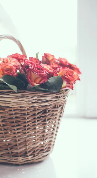 Rosas en una canasta sobre la mesa — Foto de Stock