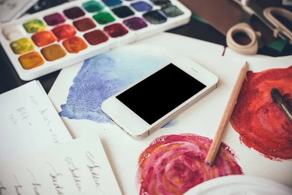 Smartphone on a table in the artist studio — Stock Photo, Image