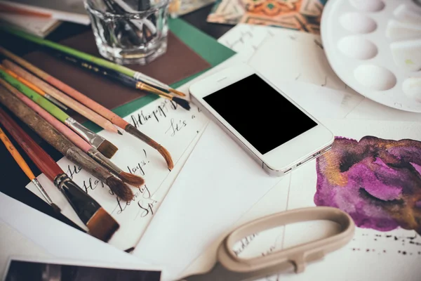 Smartphone op een tafel in de studio van de kunstenaar — Stockfoto