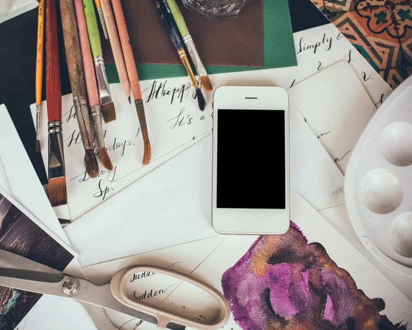 Smartphone on a table in the artist studio — Stock Photo, Image