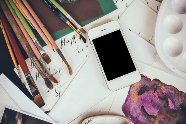 Smartphone auf einem Tisch im Künstleratelier — Stockfoto