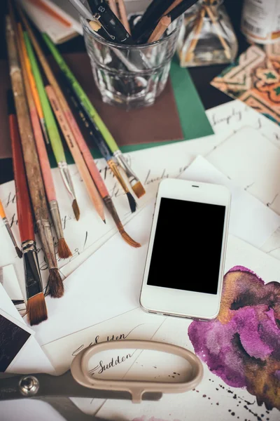 Smartphone σε ένα τραπέζι στο στούντιο καλλιτέχνη — Φωτογραφία Αρχείου
