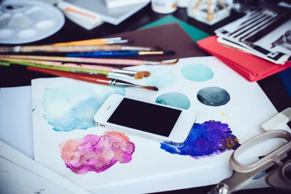Smartphone on a table in the artist studio — Stock Photo, Image