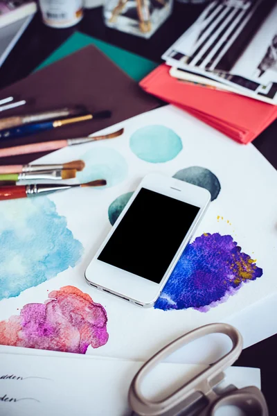 Smartphone na stole w pracowni artysty — Zdjęcie stockowe