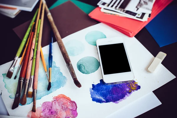 Smartphone em uma mesa no estúdio de artista — Fotografia de Stock