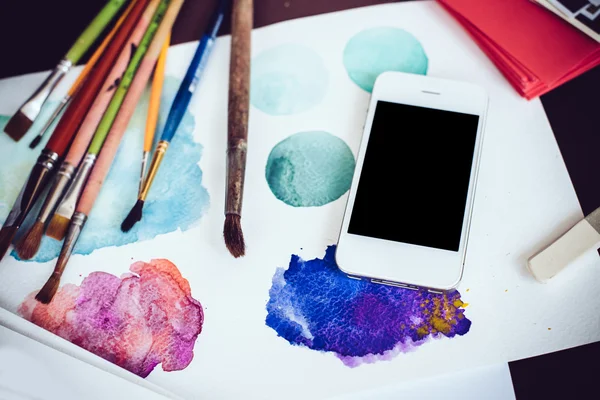 Smartphone su un tavolo nello studio dell'artista — Foto Stock