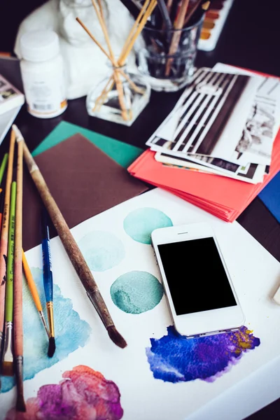 Smartphone em uma mesa no estúdio de artista — Fotografia de Stock